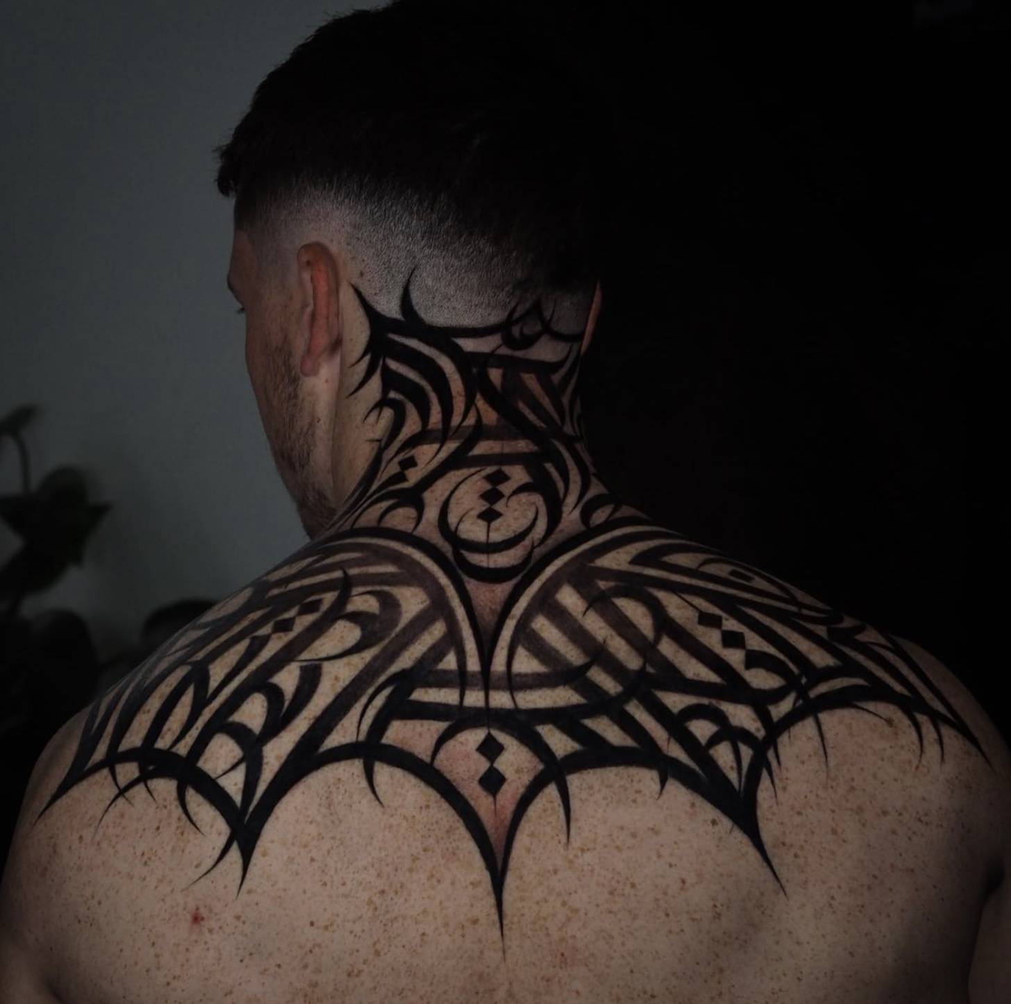Back of head and neck featuring abstract pattern with a red rose and dagger centerpiece